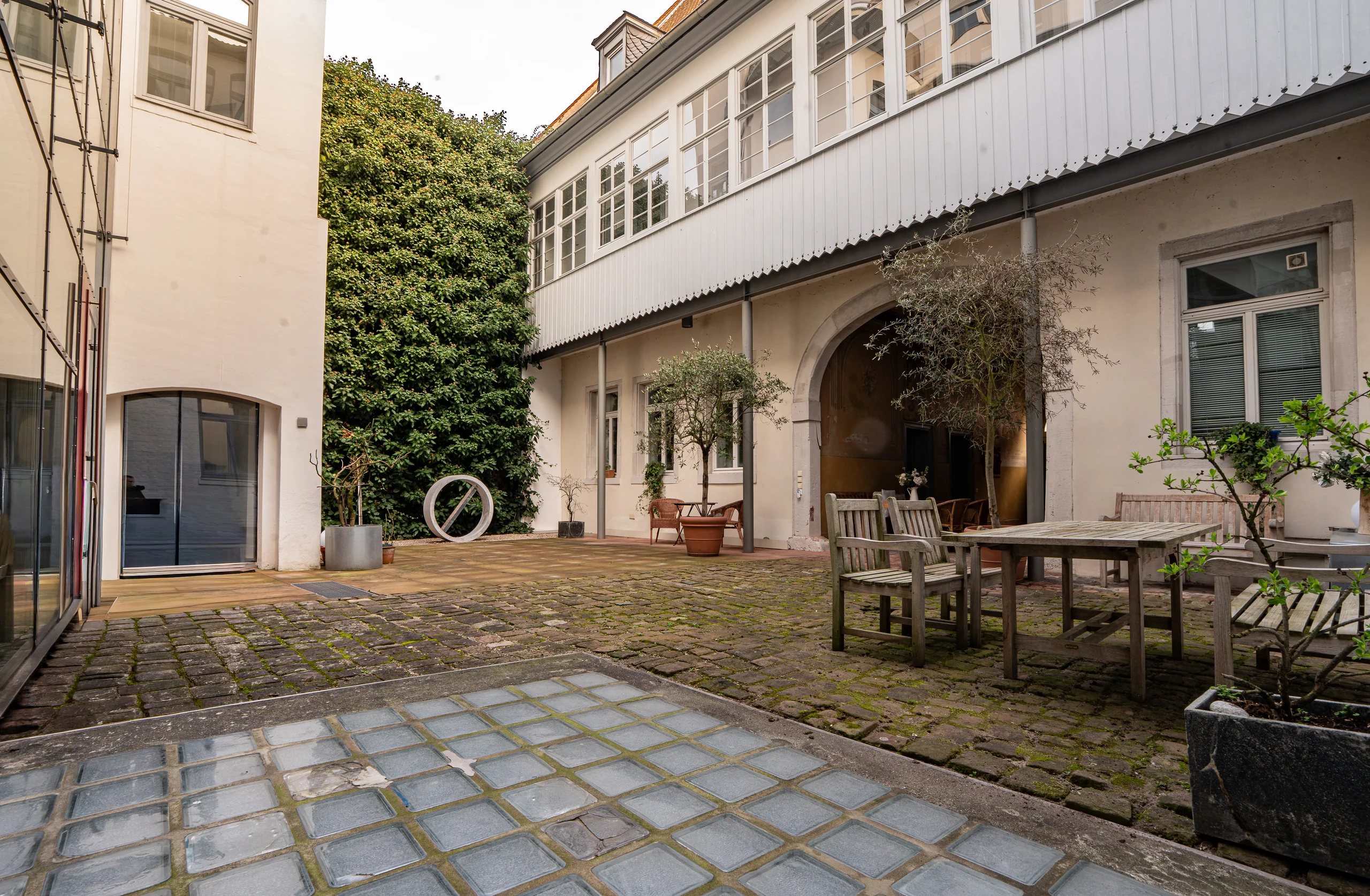 Begrünter Innenhof mit Sitzplatz zwischen Palais und Manufaktur