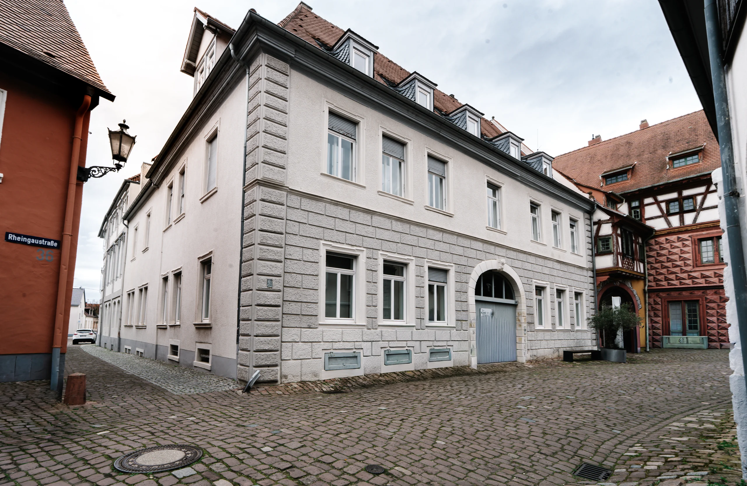 Straßenansicht des Palais neben historischen Fachwerkhäusern